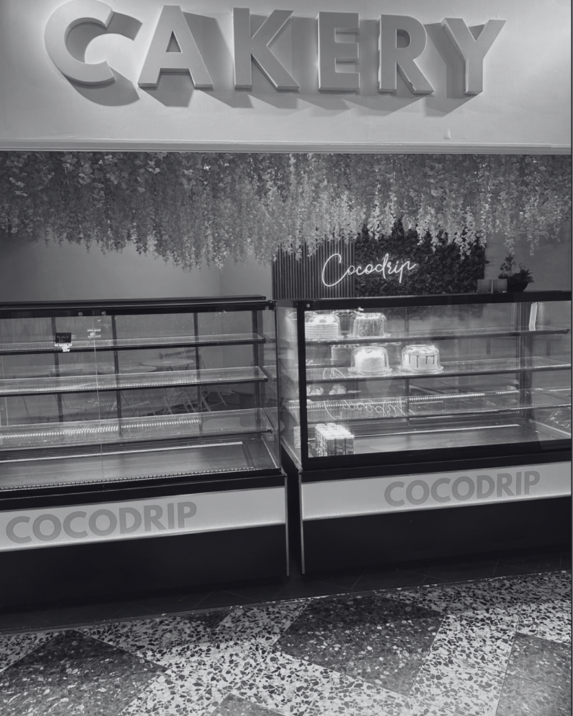 Ett café- eller bageristånd med skylten "CAKERY" och diskar märkta "COCODRIP" – redo att tas över av ny verksamhet.